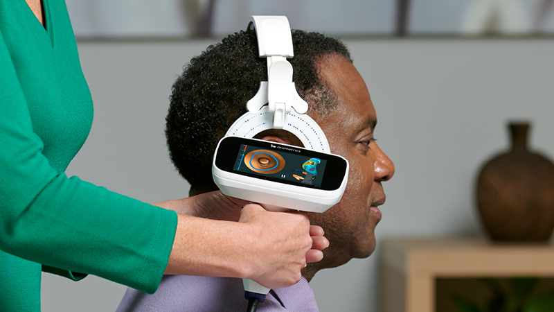 Clinician using Otoscan digital ear scanner on a patient during a 3D ear impression procedure.
