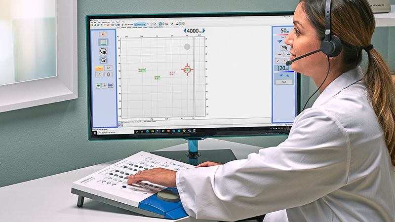 Audiologist operating PC based audiometric testing on Madsen Astera2 with tinnitus test modules during a hearing assessment.