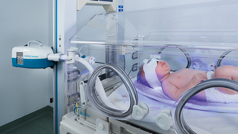 Infant receiving neonatal jaundice treatment with neoBLUE blanket Intensive LED Phototherapy System.