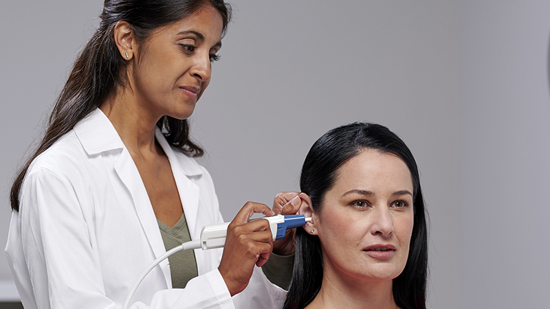 Clinician performing immittance test with Madsen Zodiac tympanometer and Gen 2 probe on adult patient